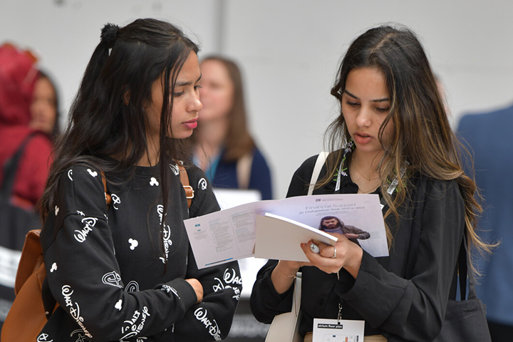 Students looking at information on a leaflet