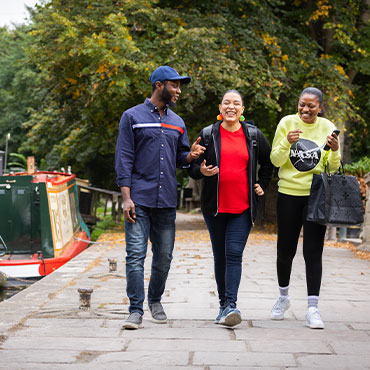 Three students walking along the canal.