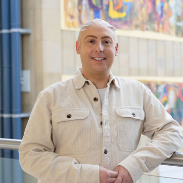 A student standing in Richmond Atrium smiling at the camera