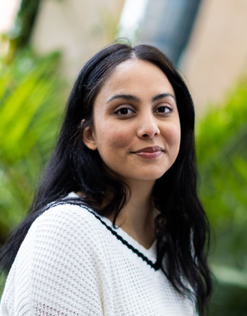 A student sitting in the Bright building at the University of Bradford smiling at the camera