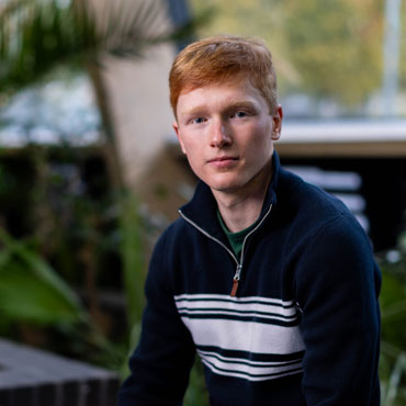 A student sitting in the Bright building at the University of Bradford looking at the camera