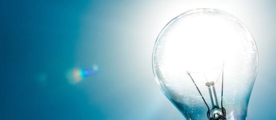 Blue sky with sun shining through part of a glass lightbulb