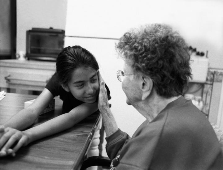 elderly lady touching girls face