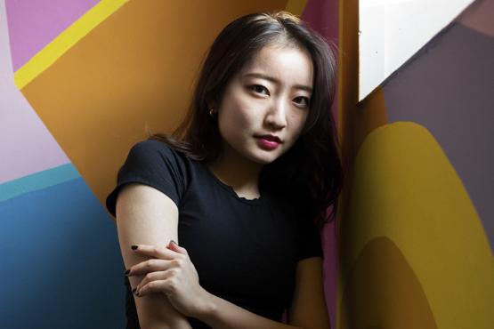 Student posing in front of a multicoloured wall