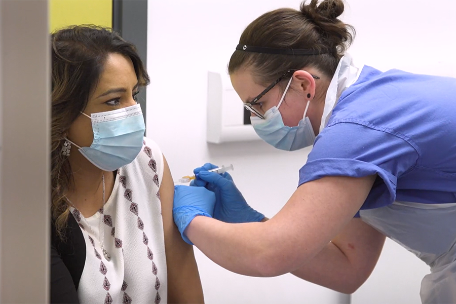 A nurse administering an injection to a female patient