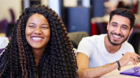 A male and female student smiling