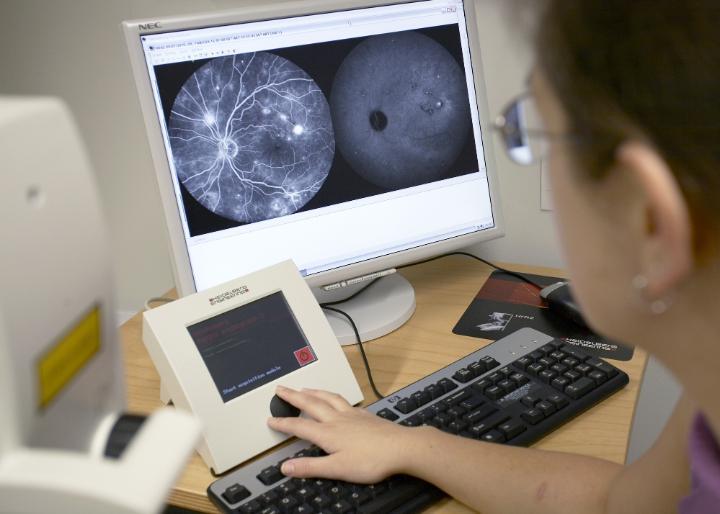 Photo of someone looking at eye examination images on a computer