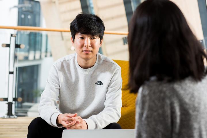 Two School of Management students sitting and talking on the Bright Building mezzanine level