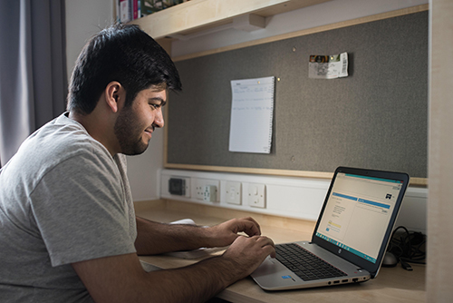 Student using a laptop at a desk