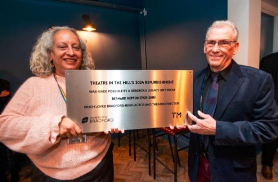 Shabina Aslam and Lawrence Gill holding a commemorative plaque