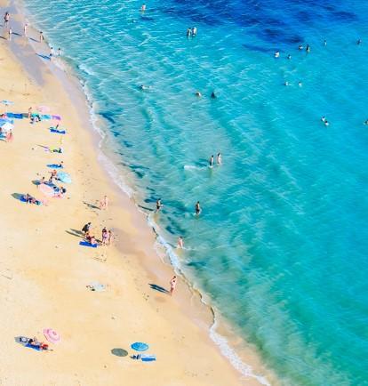 An overhead shot of people on a beach on a sunny day