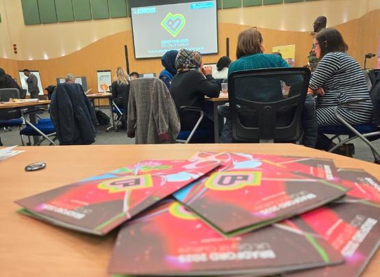 Leaflets scattered on a table at the Community Researcher graduation event