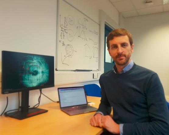 Dr Jonathan Denniss with a picture of a retina on a computer screen