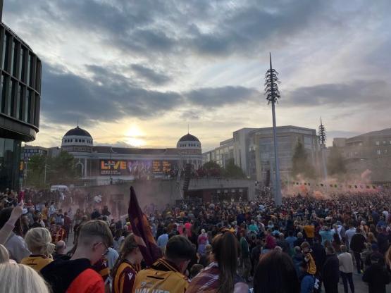 A large crowd of people gather at an outside venue for a celebration