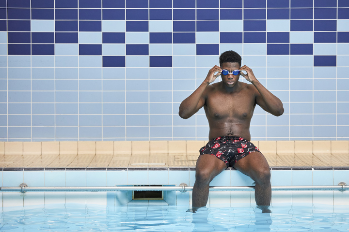 Student putting goggles on at the edge of the swimming pool