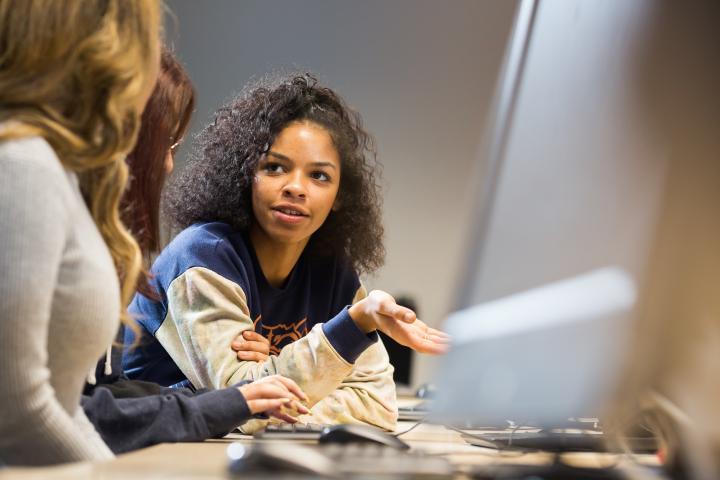 Students talking in a computer room.