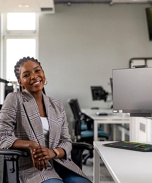 Smiling student sat in front of computes